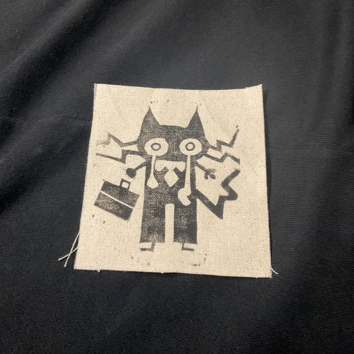 Crying cat with a suitcase on a patch.