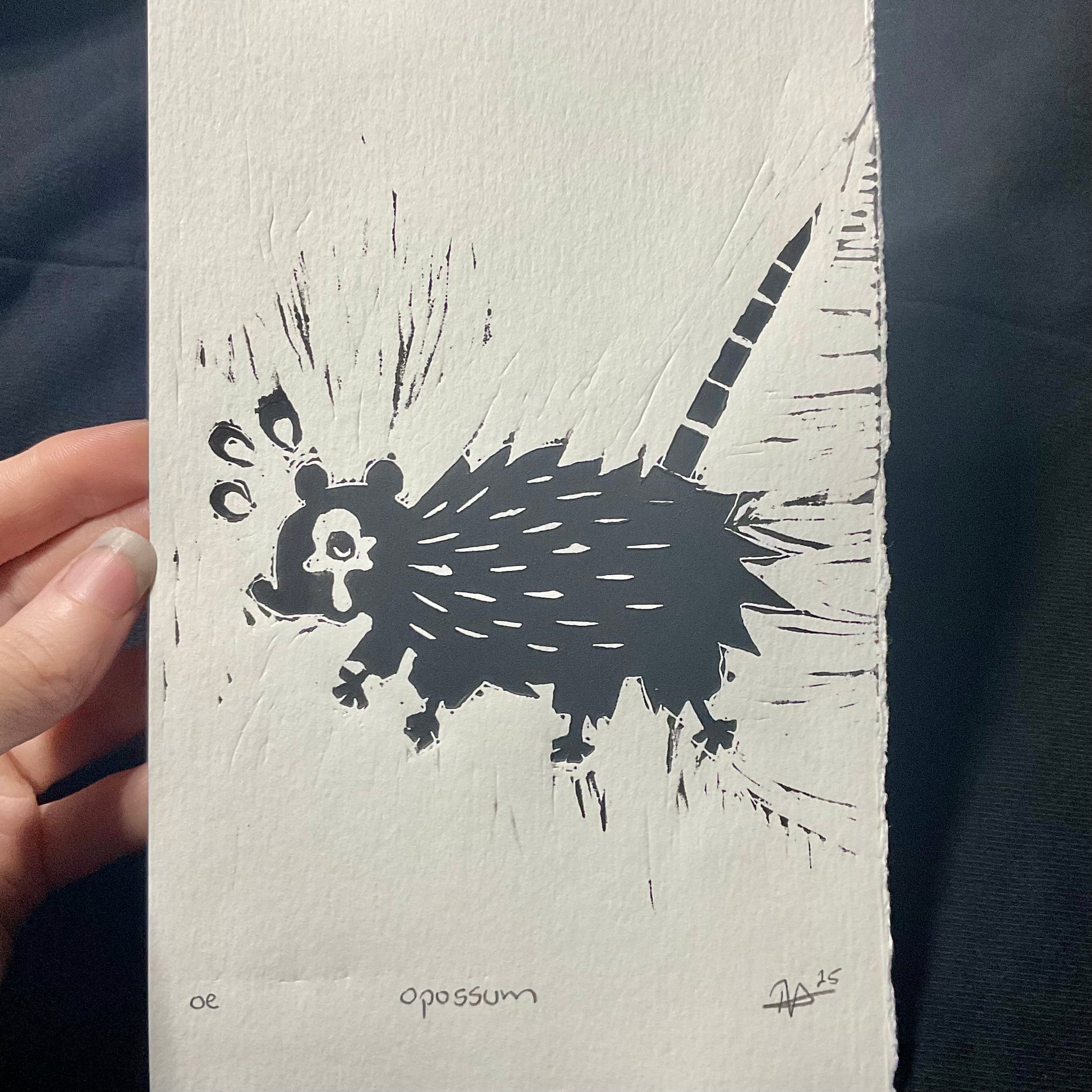 A distressed opossum printed in black ink.